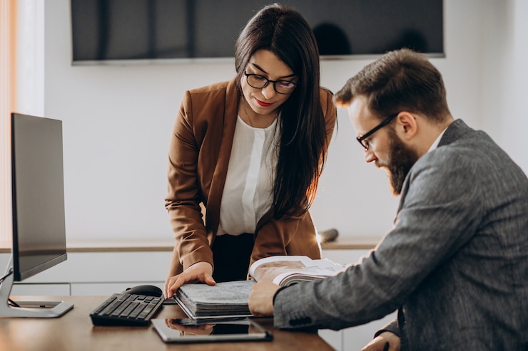 Two business partners working together in office on computer