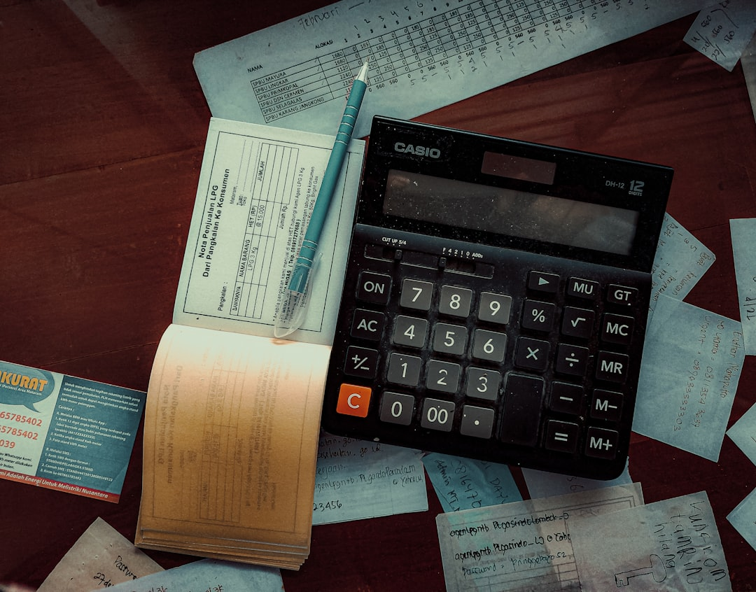 financial documents on desk with laptop and calculator